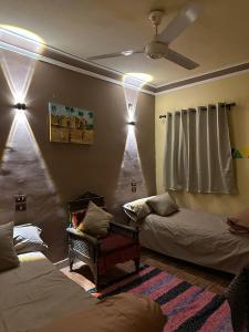 a room with two beds and a ceiling fan at SolNest Guest House in Aswan