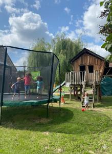 a group of children playing on a trampoline at Les Mariniers Chambres d'Hôtes avec aire de jeux proche du ZooParc de Beauval - Spa nordique en option in Mareuil-sur-Cher