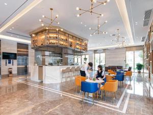 dos personas sentadas en mesas en un restaurante en Kyriad Marvelous Hotel·Yanbu International Tea City, en Guangzhou