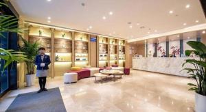 Un hombre está de pie en el vestíbulo de una tienda. en Lavande Hotels·Yichang Wanda Plaza, en Yichang
