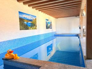 a swimming pool with a blue tiled floor and a swimming pool at De Blockhut in Grône