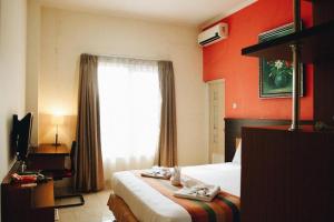 a hotel room with a bed with towels on it at Pineapple Mansion in Bonorejo