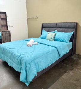 ein blaues Bett mit einem ausgestopften Tier drauf in der Unterkunft Little Stay Inn in Taiping