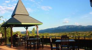 a person sitting at a table in a gazebo at Thaton Hill Resort in Mae Ai Chiang Mai