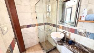 a bathroom with a sink and a glass shower at Modern Rooftop Studio in Westown, Sheikh Zayed - Near GEM & SPX Airport in Sheikh Zayed +10 photos