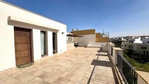 a balcony of a white building with a wooden door at Modern Rooftop Studio in Westown, Sheikh Zayed - Near GEM & SPX Airport in Sheikh Zayed