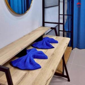 une table en bois avec des serviettes bleues au-dessus dans l'établissement Aqua Pool villa, Krabi, à Ban Nong Thale