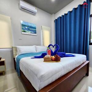 une chambre avec un lit et un rideau bleu dans l'établissement Aqua Pool villa, Krabi, à Ban Nong Thale