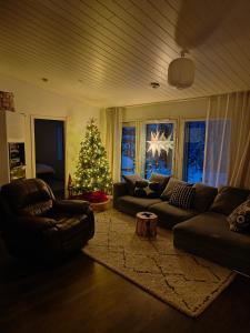 un soggiorno con un albero di Natale e un divano di Arctic Hideout a Rovaniemi Altre 2 foto
