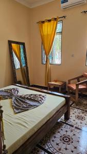 a bedroom with a bed and two windows at ZanziBalkan House Nungwi in Nungwi