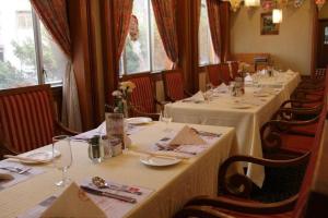 Noble Jasper Hotel Huizhou في هويزو: صف من الطاولات في مطعم مع مفارش بيضاء