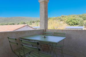 Ein Tisch und Stühle auf einem Balkon mit Aussicht in der Unterkunft Park & Suites Village Gorges de l'Hérault-Cévennes in Brissac