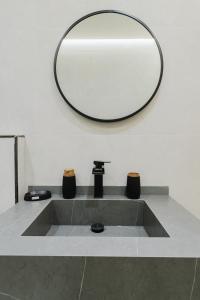 丹吉尔Studio sky lux 94的浴室水槽和墙上的镜子