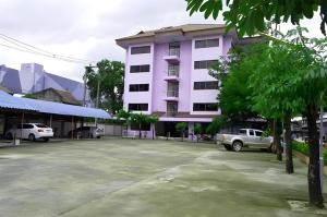 a large parking lot in front of a pink building at Premier Hotel Nakhonsrithammarat in Nakhon Si Thammarat