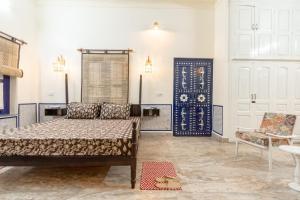 a bedroom with a bed and a chair in it at Gopagiri A unit of Anandmai Homestay in Gwalior