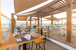 a restaurant with wooden tables and chairs and windows at Flow Spectrum Resort Sahl Hasheesh in Hurghada