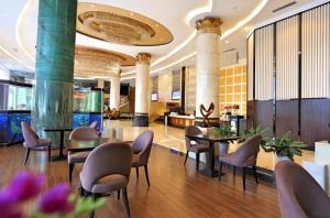 um lobby de hotel com mesas e cadeiras em Foshan Xin Hu Hotel em Nanhai
