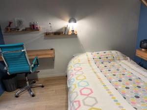 a bedroom with a bed and a desk and a chair at La chambre du Parc in Amiens