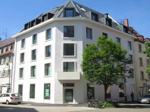 um edifício branco com um telhado pontudo em Ferienwohnungen am Theater Freiburg em Friburgo em Brisgóvia