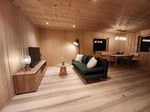 a living room with a couch and a tv and a table at Blickfang Bregenzerwald in Langenegg