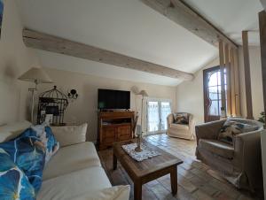 L'angélus, gîte de charme au coeur du vieux village de Sablet في Sablet: غرفة معيشة بها أريكة وطاولة