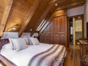 a bedroom with a large white bed with wooden walls at ADELAIDA de Alma de Nieve in Baqueira-Beret