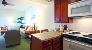 a kitchen with a stove top oven next to a living room at Wyndham Royal Sea Cliff Resort in Kailua-Kona