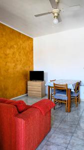 ein Wohnzimmer mit einem roten Sofa und einem Tisch in der Unterkunft Daniel House in Turin