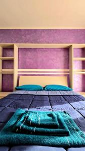 ein Schlafzimmer mit einem großen Bett mit einer lila Wand in der Unterkunft Daniel House in Turin