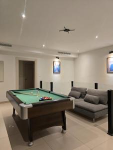 een woonkamer met een pooltafel en een bank bij RV Villas Deadsea in Sowayma