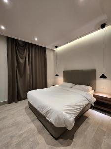 een slaapkamer met een groot wit bed met twee lampen bij RV Villas Deadsea in Sowayma