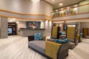 a lobby with couches and chairs and a fireplace at Greenstay Hotel & Suites Central in Springfield