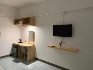 a room with a desk and a tv on a wall at SLEEPLESS ROOM Phitsanulok in Sathani Phitsanulok