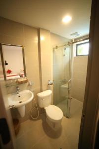 Un baño con inodoro, lavabo y ducha. en Green Hotel Da Nang, en Da Nang