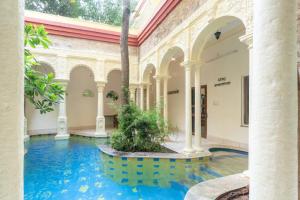 a pool in the middle of a building with columns at Gopagiri A unit of Anandmai Homestay in Gwalior
