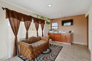Capital O Hotel Beeville - US 181 في Beeville: غرفة معيشة مع أريكة وتلفزيون
