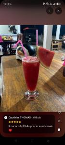 un drink in un bicchiere su un tavolo con una fetta di anguria di Grand Bungalow a Ban Ting Rai