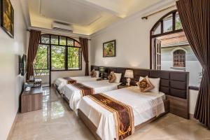 deux lits dans une chambre avec deux fenêtres dans l'établissement Vạn Xuân Royal Hotel, à La Phù