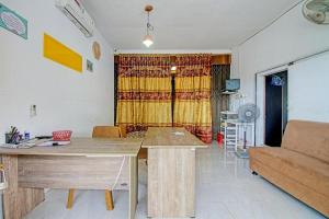 una sala de estar con una mesa y un sofá en Hotel O Mutiara Homestay Syariah Near TPA / TPSA Nurul Yakin, en Sarilamak