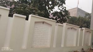 a white fence with three garage doors on it at Prayagi in Prayagraj