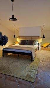 una camera da letto con un letto grande con una grande testiera di Villa Domus Dea Mondello a Palermo