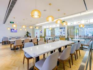 a dining room with tables and chairs and lights at GreenTree Inn Shanghai Jingan Railway Station Xinzha Road Business Hotel in Shanghai