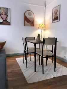 a black dining room table and chairs in a living room at l'Aiglon in LʼAigle