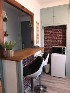 a kitchen with a counter and two stools at l'Aiglon in LʼAigle