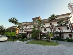ein großes Gebäude mit Palmen davor in der Unterkunft Baanna Place in Ban Na
