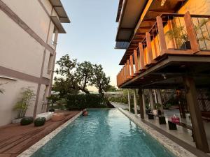 eine Person, die in einem Pool neben einem Gebäude sitzt in der Unterkunft Baanna Place in Ban Na