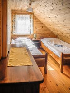a room with two beds and a table in a cabin at Dom ukryty przed światem - Szeroki Bór in Ruciane-Nida