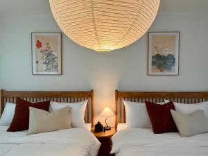 1 Schlafzimmer mit 2 Betten und einem großen Kronleuchter in der Unterkunft NEW Stay Rombus in Seoul + 22 Fotos