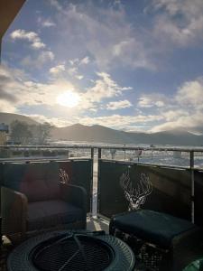 Una sala de estar con un sofá y una mesa en un balcón. en Maison El Refugi - A 15min station ski Formiguères, en Puyvalador