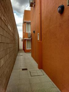 an empty hallway of a building with orange walls at Nec Apart Hotel in Las Perdices